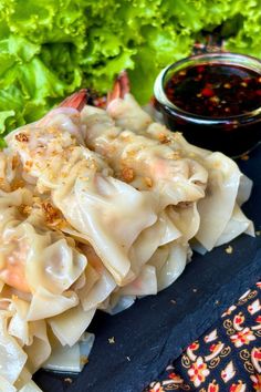 some dumplings with sauce and lettuce on the side