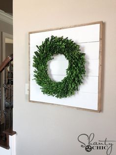 a wreath hanging on the wall above a staircase