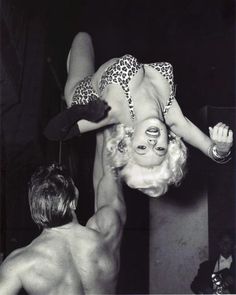 an old photo of a man and a woman doing acrobatic tricks