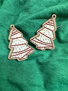 two wooden christmas trees on green fabric