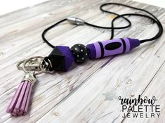 a purple and black umbrella shaped keychain with tassels hanging from it