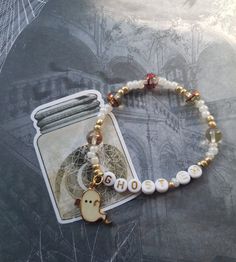 a bracelet with an image of a bird on it and beads around the clasps