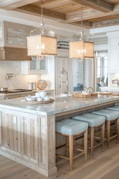 a large kitchen with an island in the middle and four stools at the end