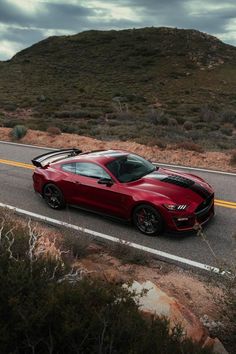 a red sports car driving down the road