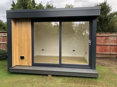 an outdoor room with sliding glass doors on the outside, and grass area in front