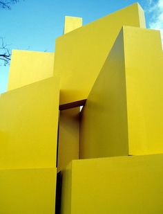 a large yellow building with a tree in the background