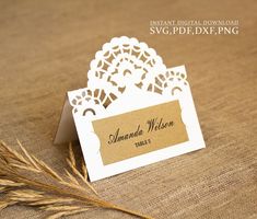 a close up of a business card on a table with some dry grass in the foreground