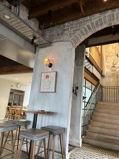 the inside of a restaurant with stools and tables in front of an open door