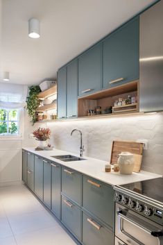 a kitchen with gray cabinets and white counter tops