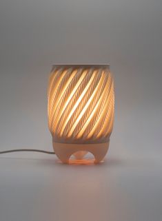 a light that is turned on and sitting on a white surface with a cord attached to it