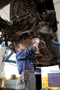 a man working on the underside of a car