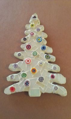 a white christmas tree made out of glass bottles and magnets on a brown surface