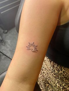 a woman with a small sun tattoo on her arm