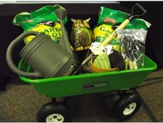 a green wagon filled with gardening supplies