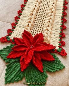 a crocheted table runner with poinsettis on it