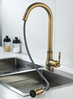 a kitchen sink with a brass faucet and soap dispenser