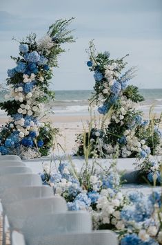 blue and white flowers are arranged on the beach