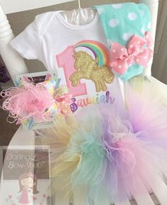 Unicorn birthday shirt or bodysuit in pastel rainbow. The glittery gold unicorn is stunning! This top can be made with any birthday number. The number is sewn with a pink polka dot fabric and unicorn with a shimmery gold fabric. The rainbow is sewn in pastel shades of pink, orange, yellow, green, blue and lavender, Her name will be added in pastel colors in a pretty cursive font. Matching bottoms and bows available in the shop! Pretty Cursive Fonts, Unicorn Birthday Shirt, Unicorn Birthday Outfit, Unicorn Themed Birthday Party, Magical Birthday, Unicorn Outfit, Ruffle Leggings, Birthday Tutu Outfit, Unicorn Shirt