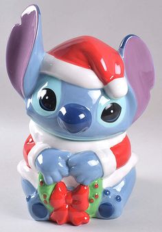 a blue and red ceramic figurine wearing a santa hat