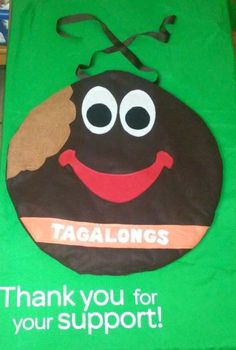 a green bag with an image of a smiling poop on it's side