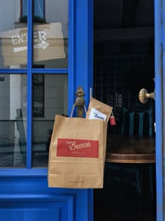 a brown paper bag sitting on top of a wooden table next to a blue door