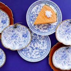 blue and white plates with pumpkins on them, one has a piece of cheese in the middle