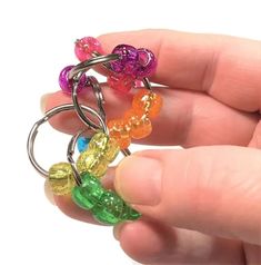 a person is holding some colorful beads in their hand