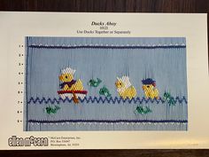 a cross stitch pattern with two ducks in the water and one duck holding a fish