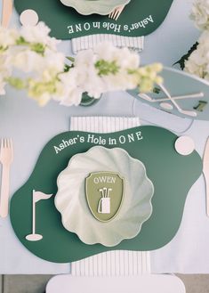 there is a place setting on the table with flowers and utensils around it