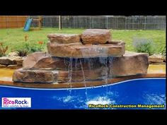 a large rock waterfall in the middle of a pool