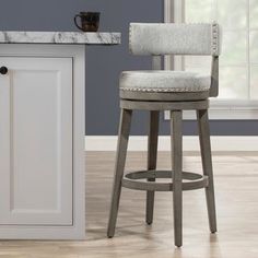 a white counter top sitting next to a wooden bar stool in a room with blue walls