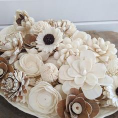 a white platter filled with lots of flowers on top of a wooden table next to a wall