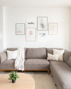 a living room filled with furniture and pictures on the wall above it's coffee table