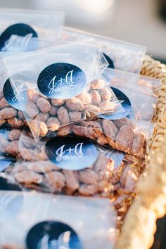 three bags filled with nuts sitting on top of a table next to each other in front of a wicker basket