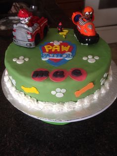 a birthday cake decorated with paw patrol and firetrucks on top of it