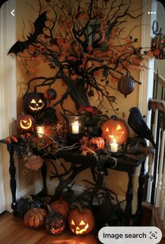 a halloween tree decorated with pumpkins and candles