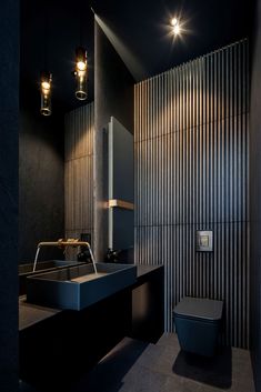 a modern bathroom with black walls and flooring