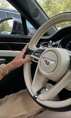 a woman is holding the steering wheel of a car with her hand on the dashboard