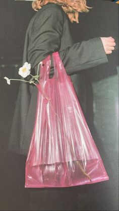 A white flower in a pink plastic bag. A Flower, Plastic Bag, A Man, A Woman, Pink, Art