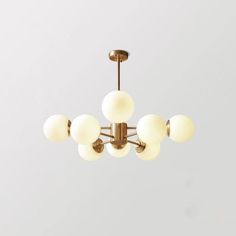 a chandelier with five white balls hanging from the ceiling