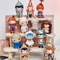 a group of figurines sitting on top of a wooden shelf next to each other