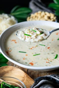 a spoon full of soup sitting on top of a table