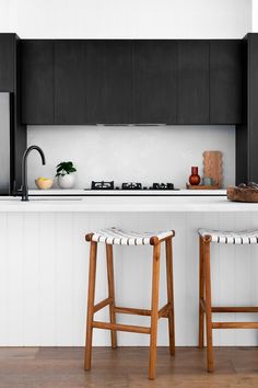 two wooden stools sitting in front of a kitchen counter