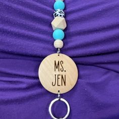 a necklace that says, ms jen on it with beads hanging from the front