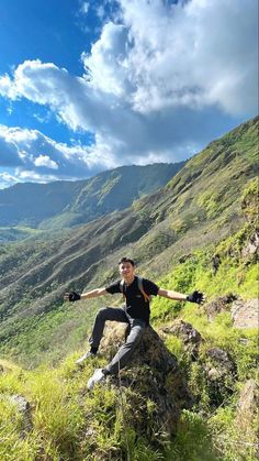 a man sitting on top of a lush green hillside