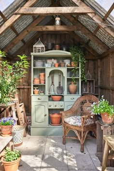 an outdoor room with potted plants on the shelves and wooden furniture in the corner