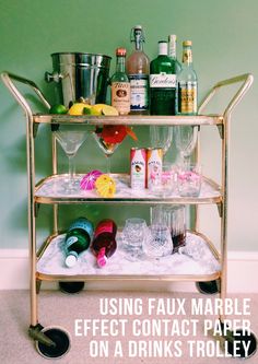 a gold bar cart filled with glasses and bottles