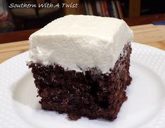 a piece of chocolate cake with white frosting on a plate