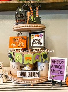 a tiered cake with halloween decorations on it and some cards attached to the top