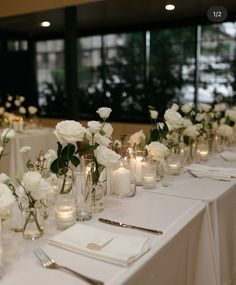 a long table with white flowers and candles